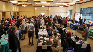 Overview of room with job seekers and employers during a Career Fair