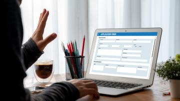 Person submitting an application form on a laptop