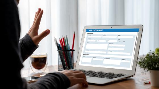 Person submitting an application form on a laptop