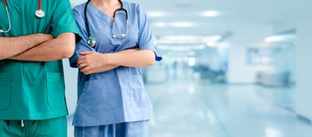 2 nurses standing in a hospital hallway with their arms crossed